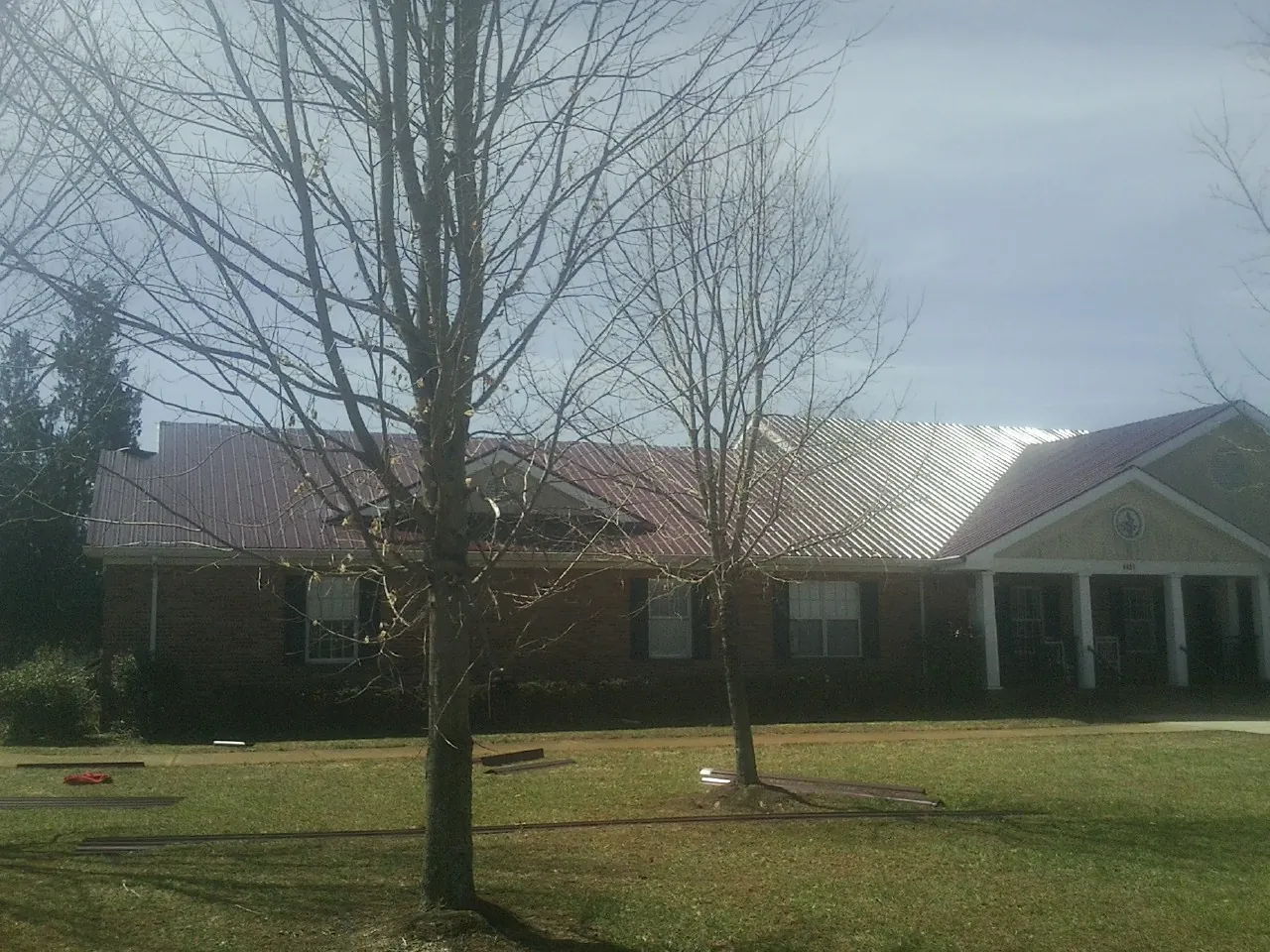 Red metal roof on a brick building seen from the front lawn in Ocean City