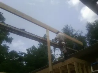 Carpenter setting a ridge beam over a new addition frame — Ice Dam Removal by Roofing Brothers in Ocean City